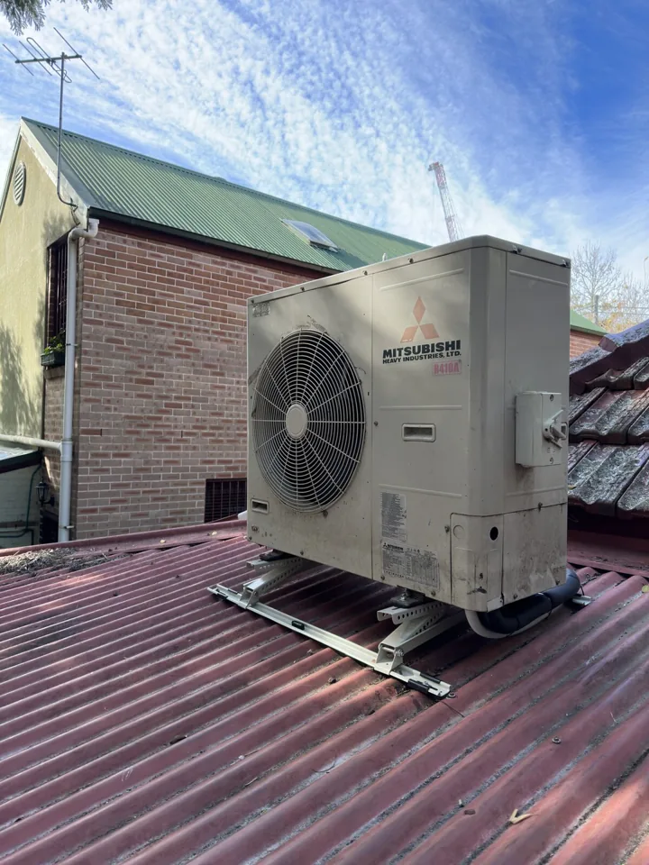 Mitsubishi outdoor air conditioning unit mounted on a corrugated metal roof
